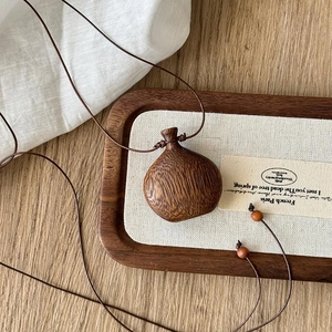 Close-up of retro wooden pendant necklace with smooth grain on canvas background