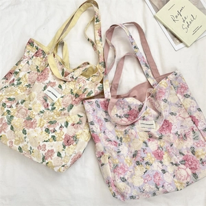 Close-up of floral print canvas tote bags with yellow and pink straps in detail