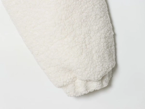 Close-up detail of soft white sherpa fleece texture on jacket sleeve cuff