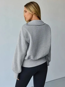 Detail of grey oversized sweatshirt with ribbed cuffs and diagonal collar zipper detail