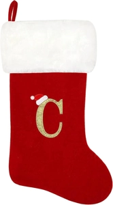 Detail of red velvet Christmas stocking with white plush cuff and gold letter C embroidery