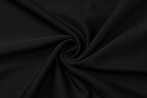 Dettaglio ravvicinato del tessuto in maglia nera con un elegante drappeggio a spirale