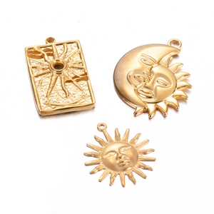 Detailed view of three vintage gold sun and moon pendants for DIY jewelry making