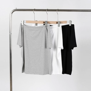 Three-color minimalist off-shoulder knit t-shirts in grey, white, and black on hangers