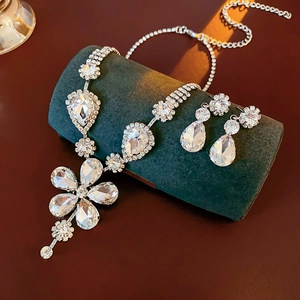 Exquisite silver floral rhinestone necklace and teardrop earrings set on green velvet