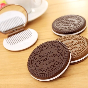 Macro view of a chocolate cookie-shaped folding hairbrush and mirror compact for travel