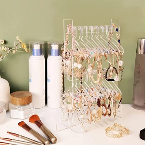 Transparent acrylic earring display stand with creative mini hanger design on a vanity