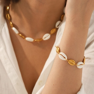 Golden shell necklace and bracelet set on a model for a beach bohemian jewelry look