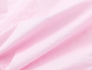 Macro shot of soft pink poplin fabric showing fine texture and delicate weave details