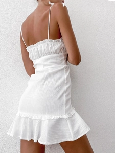 Detail of white mini dress featuring pleated texture and ruffled hemline for women