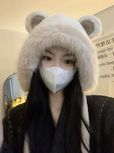 Close-up of beige plush winter hat with cute brown bear ears and warm faux fur texture