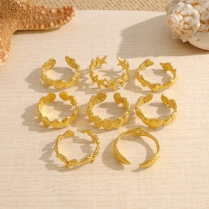 8-piece set of gold starfish and seashell ocean-themed rings for women on beige background