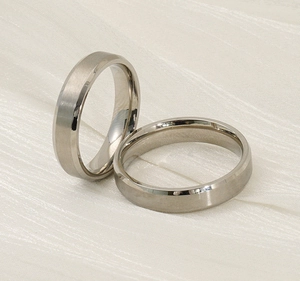 Detail von silbernen Edelstahl-Partnerringen mit matter und polierter Oberfläche auf Seide