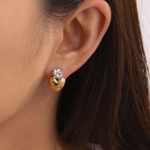 Élégantes boucles d'oreilles cœur en or avec zircons portées par un mannequin femme