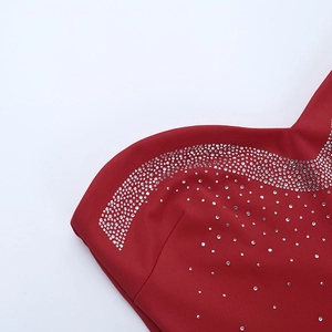 Close-up of sparkling silver rhinestones on bright red satin evening dress fabric