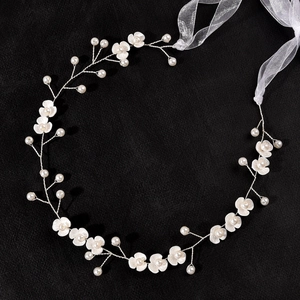 Detail of bridal headband with handmade 3-petal silk flowers and pearls on silver wire