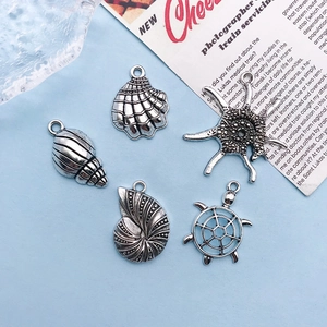 Close-up of silver sea turtle and starfish alloy charms for jewelry making