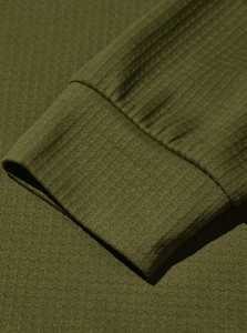 Macro view of army green waffle knit texture and ribbed cuff sewing craftsmanship