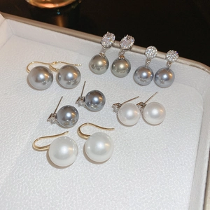 Macro shot of pearl earrings with cubic zirconia inlay in white, grey and silver tones