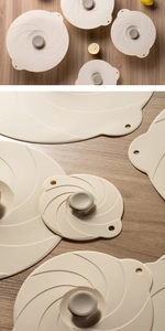 Close-up of beige silicone lids with spiral design and heat-resistant pull tabs on wood