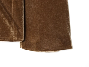 Gros plan sur la texture du tissu en velours marron des poignets de l'ensemble tailleur