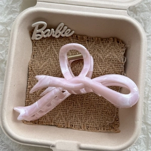 Detailed macro view of pink marble acetate bow hair claw clip with metallic spring
