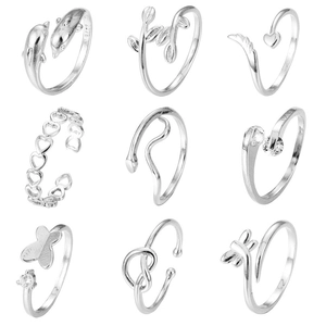 Detailed macro shot of 9-piece silver adjustable rings featuring dolphin and heart designs