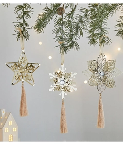 Macro shot of metallic snowflake ornament with diamond inlay and champagne silk tassels