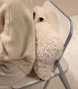 Détail du coussin mouton en peluche blanc crème montrant la texture et l'étiquette