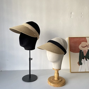 Detailed texture of handmade straw visors with beige and black ribbed edge trims