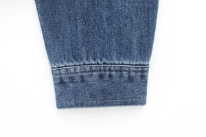 Detailed macro view of the blue washed denim jacket cuff with reinforced stitching