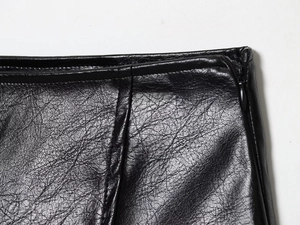 Détail de couture à la taille sur veste en similicuir noir avec fermeture éclair invisible