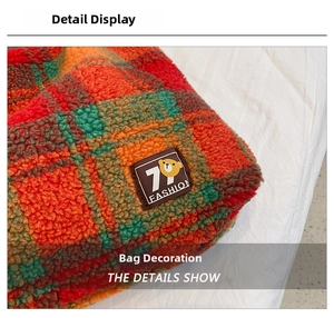 Detail of plaid fleece tote bag featuring a leather patch with cartoon bear and text