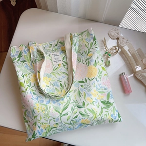 Détail macro du sac cabas en coton fleuri avec étiquette texte vintage sur fond blanc
