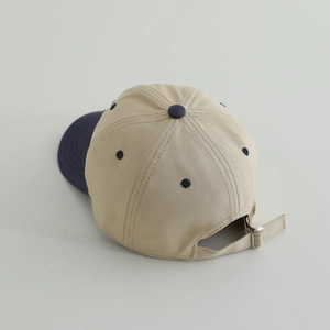 Detail of adjustable metal buckle and contrast color stitching on cotton baseball cap