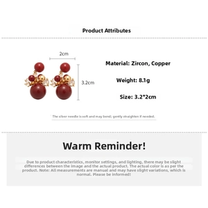 Detailed view of red gemstone earrings with gold accents and cubic zirconia stones
