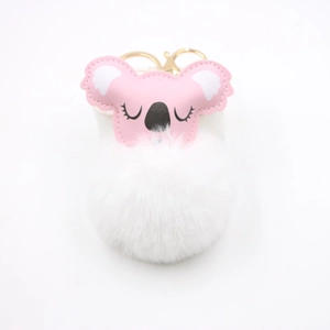 Close-up of pink and white koala fluffy pompom keychain with golden metal clasp