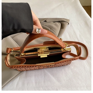 Detailed top view of caramel woven leather bag with gold hardware and interior structure