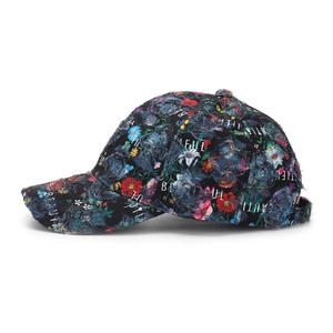 Dettaglio del cappellino vintage a fiori con bordi consumati e scritte ricamate