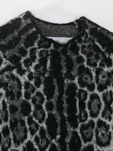 Detailaufnahme des Leopardenstrick-Ausschnitts mit Stoffstruktur und Frau-Etikett