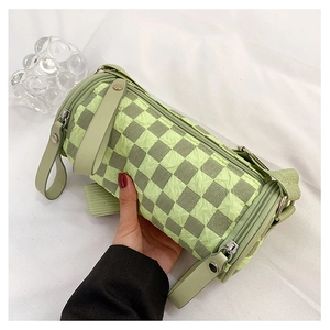 Detail view of small green checkerboard barrel bag with bubble textured fabric handle