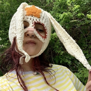 Detail of handmade crochet balaclava with rabbit ears and orange star ornament