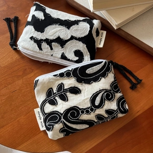Detail of embroidered bohemian coin purse with paisley patterns and black tassel