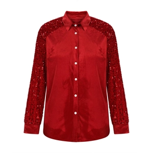 Detail of red satin blouse featuring sequined sleeves and elegant white button closure