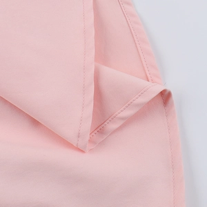 Gros plan des coutures fines et de la texture d'une robe d'été dos nu rose clair