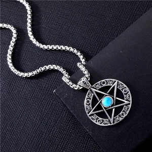 Detailed shot of a silver star pendant with turquoise inlay on a ball chain