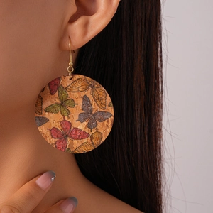 Detail of bohemian round earrings with multi-color butterfly print on cork material