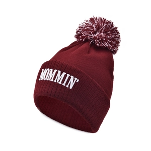 Detail of burgundy knit beanie with MOMMIN embroidery and mixed color fluffy pom-pom