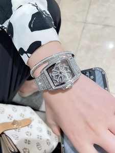 Detailed view of luxury silver rhinestone tonneau watch with rotating clover dial and bracelet