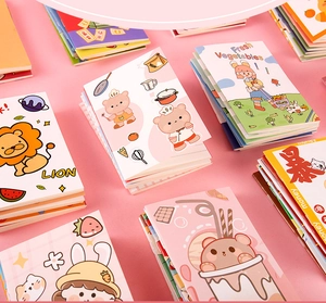 Flat lay of colorful cartoon mini notebooks with cute characters on pink background